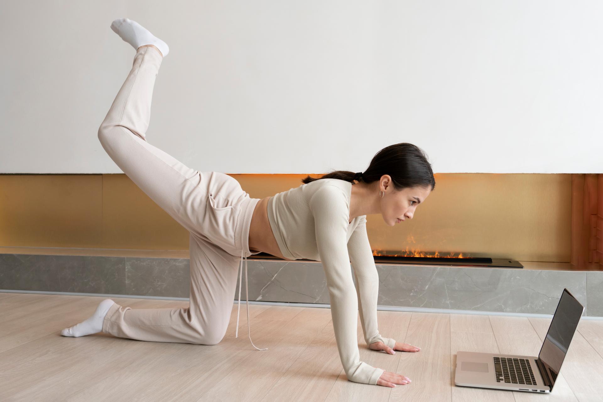 full-shot-woman-exercising-with-laptop-home (1)